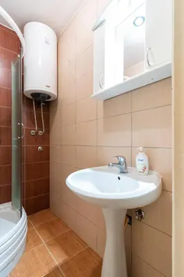 a bathroom with a sink and a toilet and a mirror at Captain's Crib in Belgrade