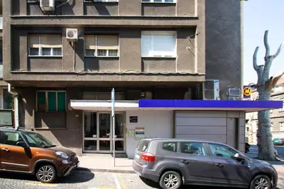 two cars parked in a parking lot in front of a building at Captain's Crib in Belgrade
