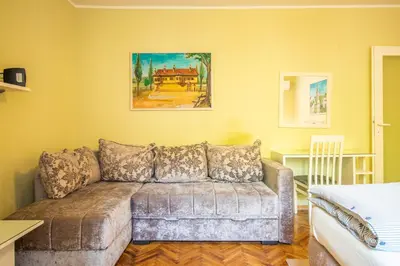 a living room with a couch and a painting on the wall at Captain's Crib in Belgrade