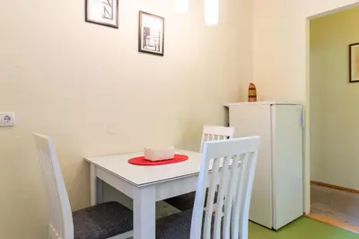 a white table with two chairs and a white refrigerator at Captain's Crib in Belgrade