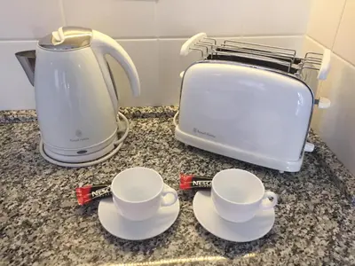 two coffee cups and a toaster on a counter at Apartment Treci in Belgrade