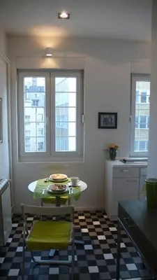 a kitchen with a table and two windows and a table and chairs at Apartment Treci in Belgrade