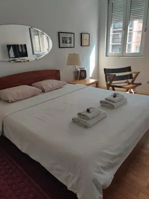 a bedroom with a large white bed with two towels on it at Apartment Treci in Belgrade