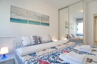 a white bedroom with a bed with pillows at Bianca in Belgrade