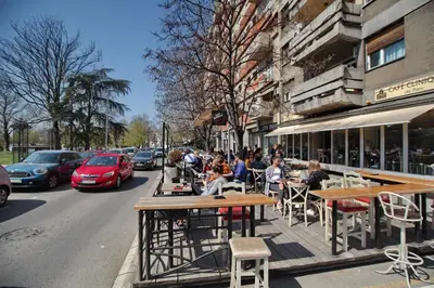 a group of people sitting at tables on a city street at Bianca in Belgrade