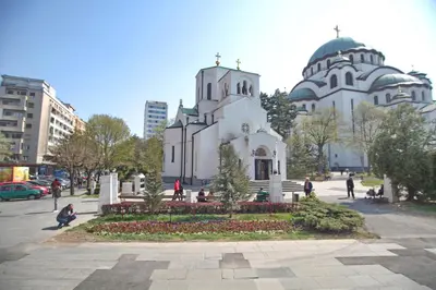 a white church with two domes in a city at Bianca in Belgrade