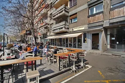 a group of people sitting at tables on a city street at Bianca in Belgrade