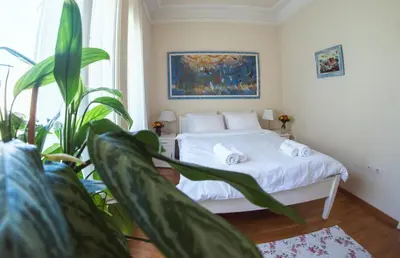 a bedroom with a bed and a plant at Crown apartment with garden view in Belgrade