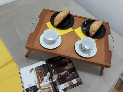 a table with two plates and bowls of bread on it at Sweet Yellow Apartment in Belgrade