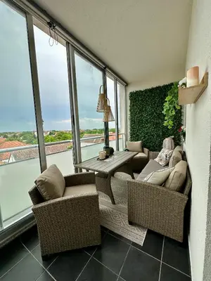 a living room with a couch and chairs and windows at Apartman SUN in Inđija