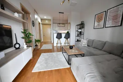 a living room with a couch and a table at Apartman SUN in Inđija