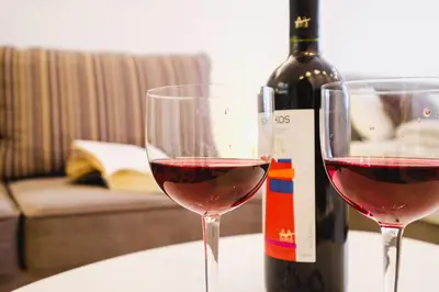 two glasses of red wine next to a bottle of wine at Apartment Hana Lux-Cozy Studio Near Danube, Quite & Bright in Belgrade