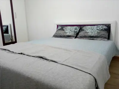 a bed in a white room with a bedspread and pillows at Anni in Belgrade