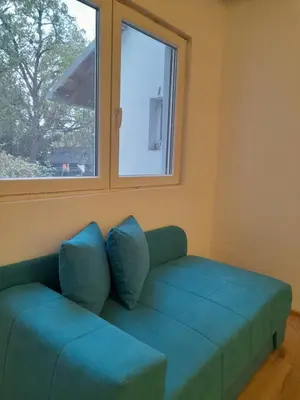 a green couch in a room with a window at Anni in Belgrade