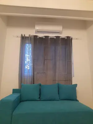 a green couch in a room with a window at Anni in Belgrade