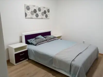 a bedroom with a bed with a nightstand and a picture at Anni in Belgrade