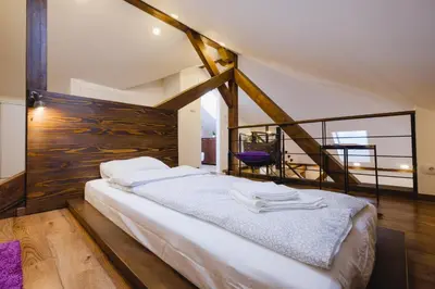 a bedroom with a large bed with a wooden wall at Apartment Lea Lux-5 min to Danube, Quite & Cozy, Easy parking nearby in Belgrade