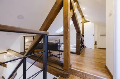 a staircase in a loft conversion with wooden beams at Apartment Lea Lux-5 min to Danube, Quite & Cozy, Easy parking nearby in Belgrade