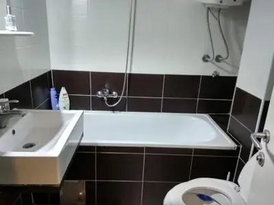 a bathroom with a tub and a toilet and a sink at Sobe Neva in Belgrade
