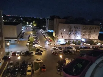 a parking lot filled with cars at night at Sobe Neva in Belgrade