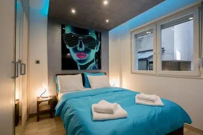 a bedroom with a blue bed with two towels on it at Cosmopolitan One Apartment in Belgrade