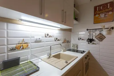a white kitchen with a sink and a counter at Cosmopolitan One Apartment in Belgrade