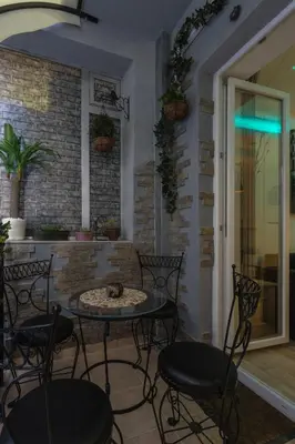 a patio with a table and chairs in a room at Cosmopolitan One Apartment in Belgrade