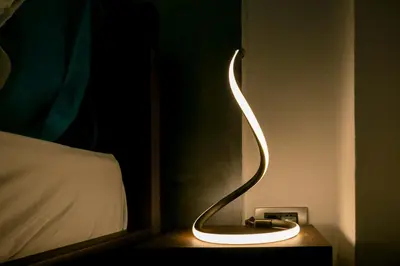 a light on a night stand next to a bed at Cosmopolitan One Apartment in Belgrade