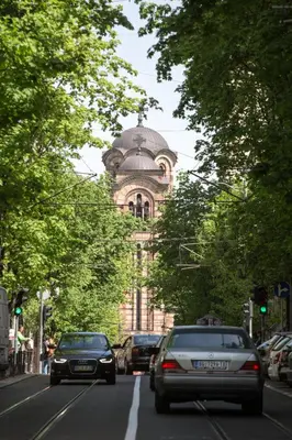 a building on a street with cars driving down the street at Cosmopolitan One Apartment in Belgrade