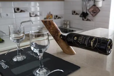 a bottle of wine and two glasses on a counter at Cosmopolitan One Apartment in Belgrade