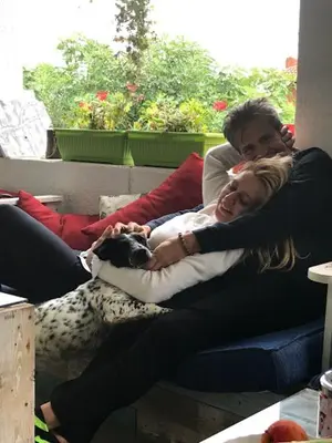 a man and woman sitting on a couch with a dog at Branch in Arandjelovac