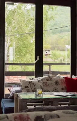 a living room with a couch and a large window at Branch in Arandjelovac