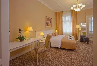 a large hotel room with a bed and a desk at Booking Rooms in Belgrade