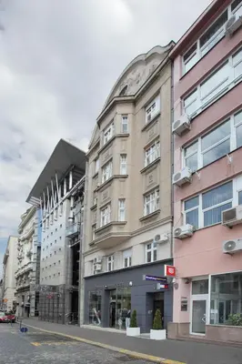 a tall building on a city street with buildings at Booking Rooms in Belgrade