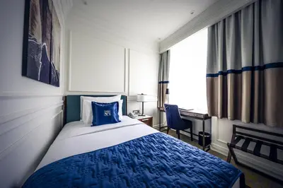 a bedroom with a blue and white bed and a desk at Hotel Centar No.1 in Belgrade