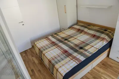 a small bed in a small room at Puzzle Apartment in Dedinje