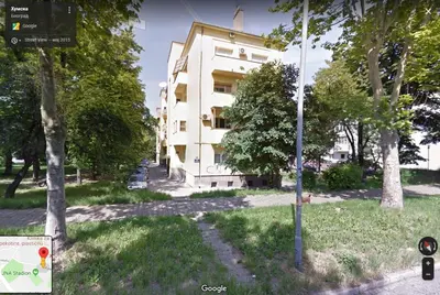 a white building with trees in front of it at Puzzle Apartment in Dedinje