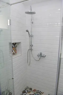 a shower with a glass door in a bathroom at Puzzle Apartment in Dedinje
