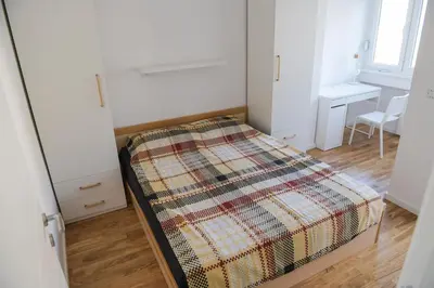 a bedroom with a bed with a blanket on it at Puzzle Apartment in Dedinje