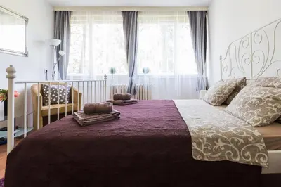 a bedroom with a large bed with a purple blanket at GRACE in Tošin Bunar