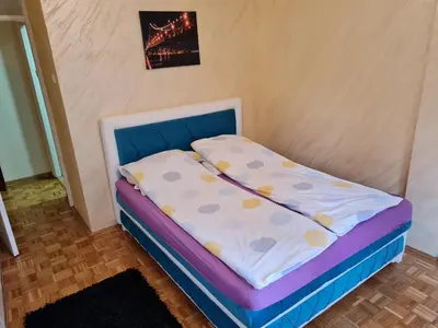 a small bed in a corner of a room at Apartment Delta Sava New Belgrade in Belgrade