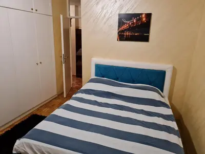 a bedroom with a bed with blue and white stripes at Apartment Delta Sava New Belgrade in Belgrade