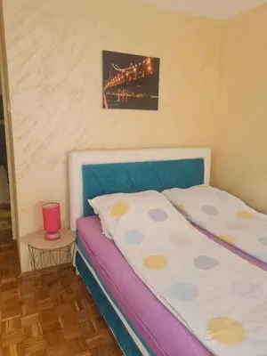 a small bedroom with a bed and a table at Apartment Delta Sava New Belgrade in Belgrade