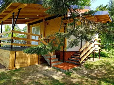 a wooden cabin with stairs leading to a porch at HELONA in Arandjelovac