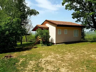 a small house in a yard next to a tree at HELONA in Arandjelovac