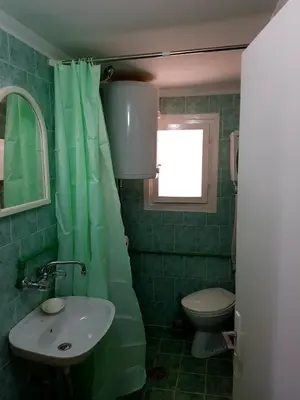 a green bathroom with a sink and a toilet at HELONA in Arandjelovac