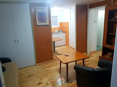 a living room with a table and a kitchen at HELONA in Arandjelovac