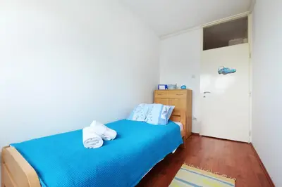 a bedroom with a blue bed with towels on it at Belgrade Sweet Home Apartment in Belgrade