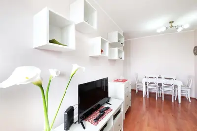 a living room with a flat screen tv on a white desk at Belgrade Sweet Home Apartment in Belgrade