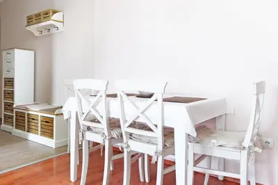a white dining room table with white chairs at Belgrade Sweet Home Apartment in Belgrade